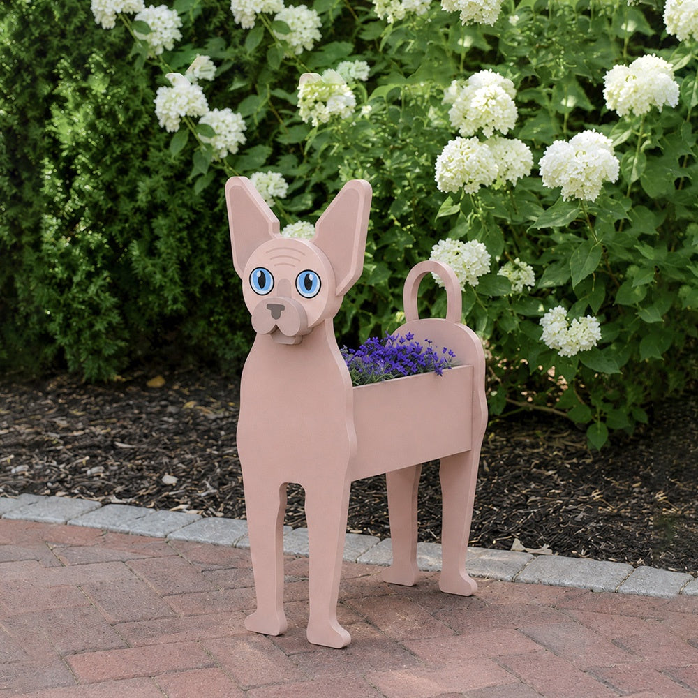 Sphynx cat planter filled with fresh flowers is placed in the garden