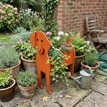 Vizsla dog planter filled with fresh flowers is placed in the garden