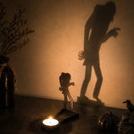 Walking zombie halloween metal candle holder casting a spooky shadow on the wall