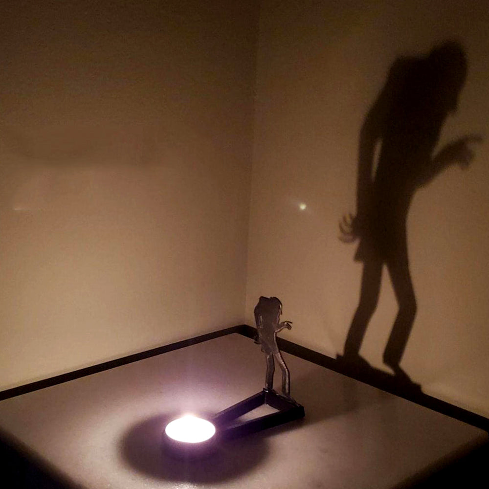 Walking zombie halloween metal candle holder casting a spooky shadow on the wall
