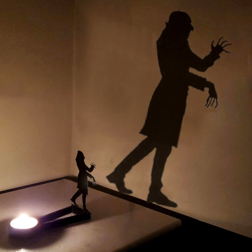 Wandering zombie halloween metal candle holder casting a spooky shadow on the wall