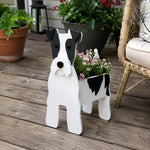 Wire Fox Terrier dog planter filled with fresh flowers is placed in the garden