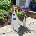 Wire Fox Terrier dog planter filled with fresh flowers is placed in the garden