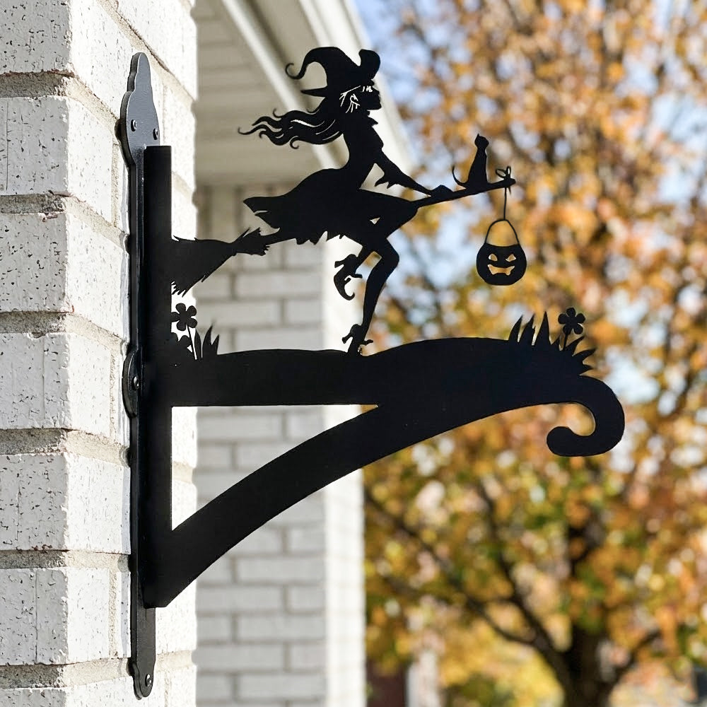 Witch and black cat metal hanging basket bracket mounted on outdoor wall for plant decoration