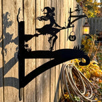Witch and black cat metal hanging basket bracket mounted on outdoor wall for plant decoration