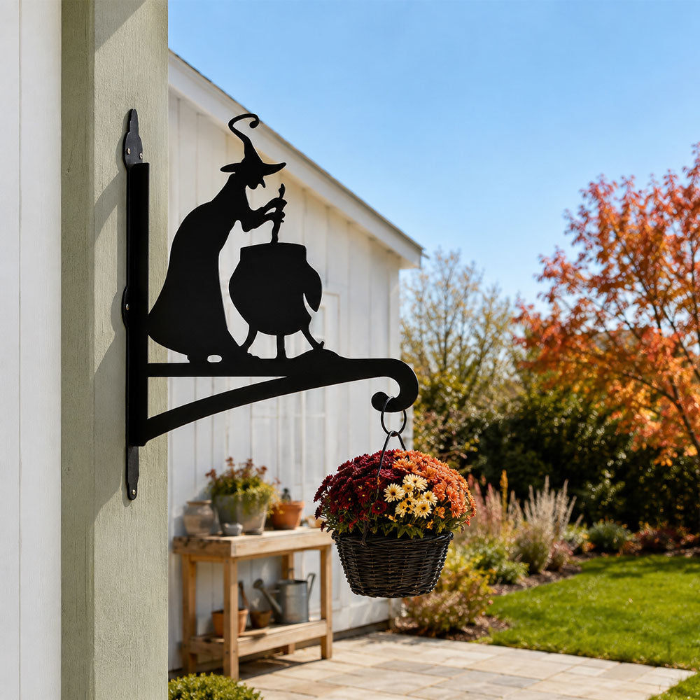 Witch and cauldron metal hanging basket bracket mounted on outdoor wall for plant decoration